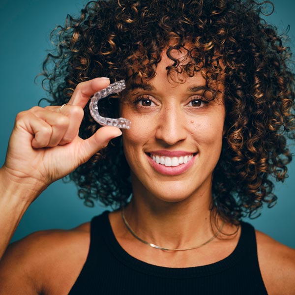 woman holding clear aligner