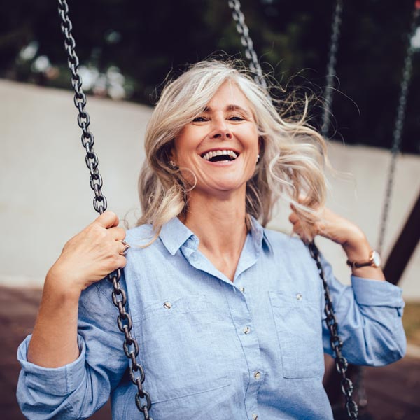 laughing senior woman on swing